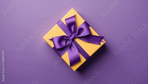 Yellow minimal gift box with purple ribbon standing isolated on purple background, top view, copy space, Valentine's Day, Mother's Day, Women's Day