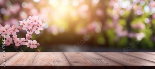 An empty wooden table top overlooking a blooming spring garden. Blurred background.