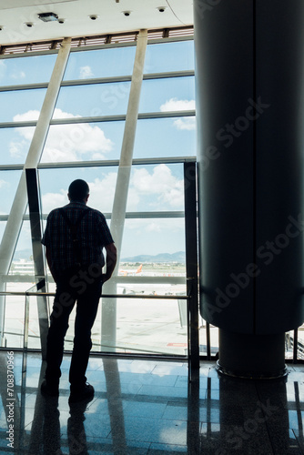 Voyageur à l'aéroport de Palma. Passager attendant son avion au terminal d'un aéroport. Silhouette d'un homme regardant le tarmac avant l'embarquement. Voyager en avion. Regarder le traffic aérien.