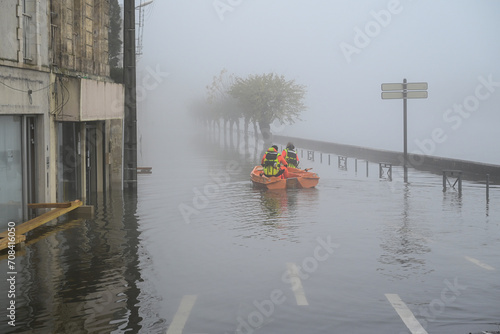 Route inondée et canot de sauvetage des pompiers pendant les inondations de Saintes.