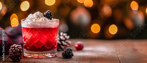 Composition of a red cocktail in a transparent glass, ice, whipped cream and a plump blackberry