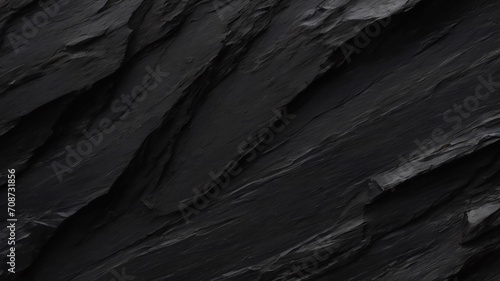 The dark texture of the stone, raw black obsidian, hardened volcanic lava glass, natural patterns and shapes on the stone section.