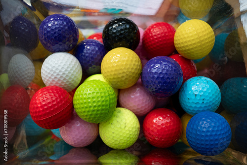 Pelotas de golf de colores en un recipiente