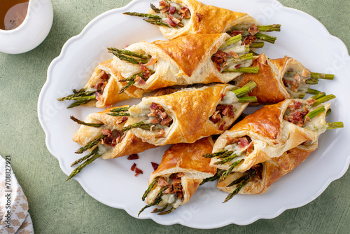 Asparagus appetizers wrapped in puff pastry with melted cheese