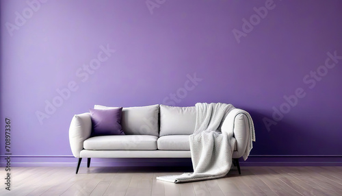 Sofa and pouf covered with blanket against purple wall with copy space. Minimalist interior design of modern living room.