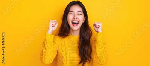 Joyful Asian woman celebrating an online victory, happy about positive news, motivated by success and new opportunity.