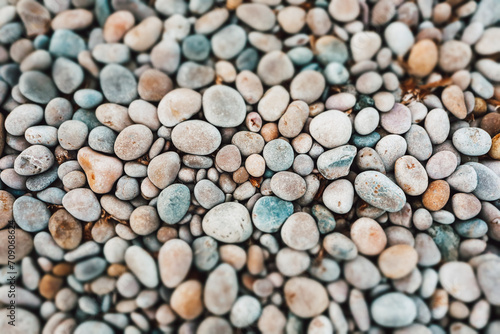 Pebbles pattern. Small grey, yellow stones, pebble on sea, ocean coast. Stone abstract natural background. Rocks on a shore top view. Marine theme.