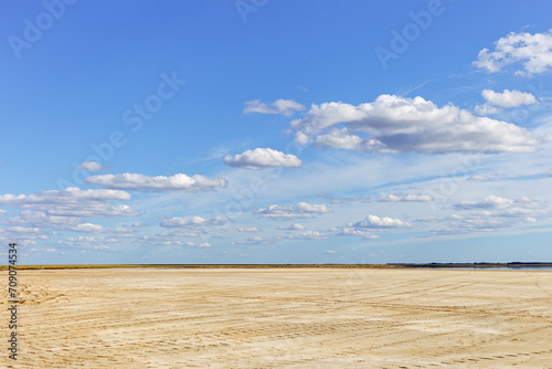 Scenic summer landscape blue sky clouds, water surface and sandy shore. Minimal aesthetic nature view. Pastel colors cloudscape. Ulzhay (Uldjay) salt lake with medicinal mud in Omsk region