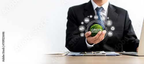 Businessman holding green globe with world map and icons green business idea A repository for green business, finance and sustainable investing. Carbon credits. investment saves money