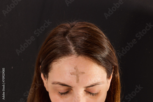 Woman with cross made from ash on forehead. Ash wednesday concept.