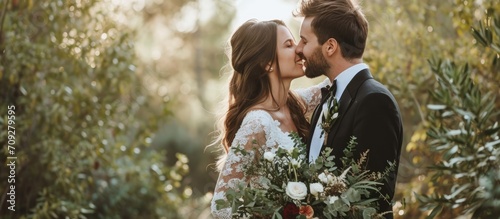Romantic connection and commitment are celebrated as a couple kisses, smiles, and laughs amidst nature at a wedding ceremony.