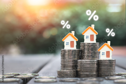 Home finance and Mortgage Interest Rates. House model with percentage sign on many level of stack of coins. Refinance home loan, Repayments, Property Tax, business and financial concept.