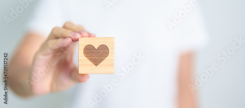 Hand holding heart block for health care, love, organ donation, charity, happy family, wellbeing and insurance concepts. world heart day, health day and mental health day