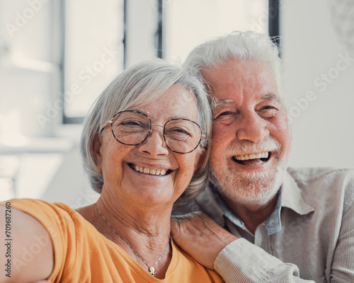 Head shot portrait happy senior couple taking selfie, having fun with phone cam, smiling aged wife and husband hugging, looking at camera, posing for photo, aged man vlogger recording video.