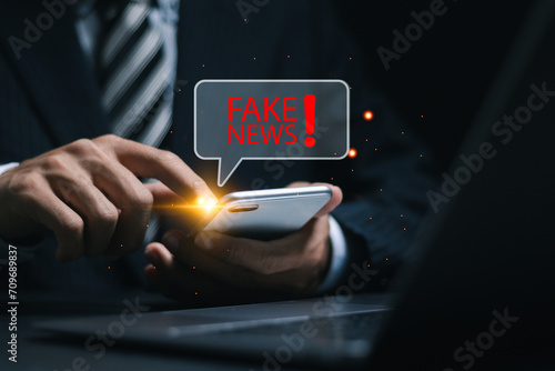 Fake news, Person use smartphone with fake news word. Online misinformation and news distortion.