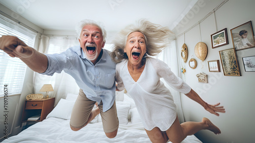 Funny happy Elderly couple Jumping on the bed at home