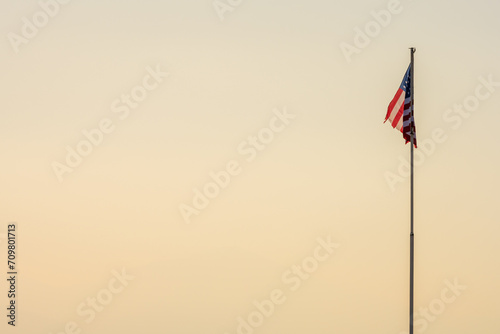 Le drapeau américain flotte mollement devant un ciel hivernal au crépuscule. Symbole d'un empire en déclin ?