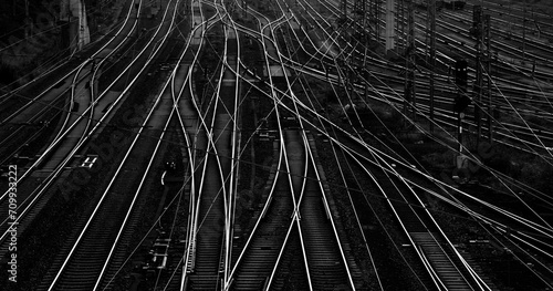 Infrastructure wide angle panorama with railway tracks, switches, crossings and catenary at a big station in Hagen. Geometrical structures, lines s. Black and white transportation background 