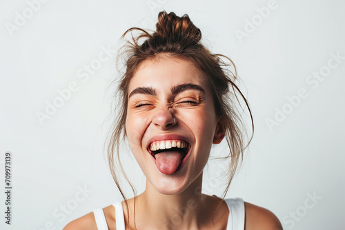 closeup shot of attractive young woman winking joyfully and showing tongue sassy on white isolated background