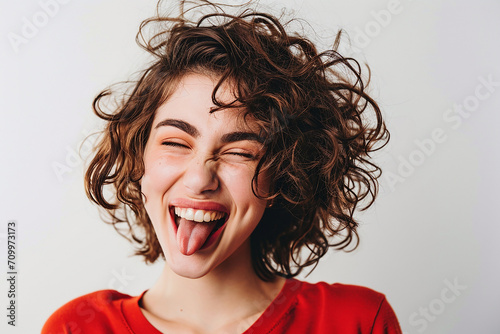 closeup shot of attractive young woman winking joyfully and showing tongue sassy on white isolated background