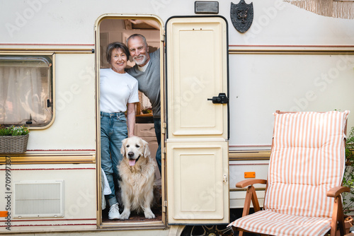 Senior old elderly family spouses husband and wife traveling together in camper van with golden retriever labrador domestic animal caravanning in motor home
