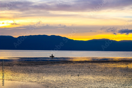Fisherman working at sunrise on a beautiful lake