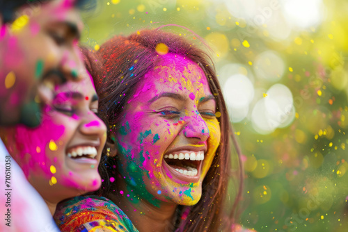 Happy laughing Indian woman covered with coloured powders on Holi celebration. 