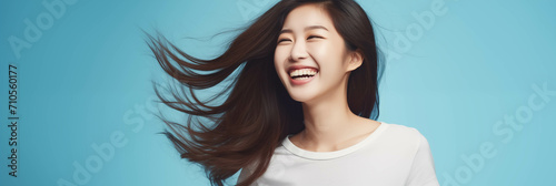 Happy Asian woman on blue background.