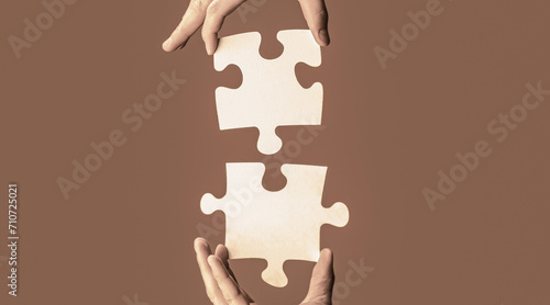 Closeup hands of man connecting jigsaw puzzle. Two hands trying to connect couple puzzle. Hand connecting jigsaw puzzle. Man hands connecting couple puzzle piece