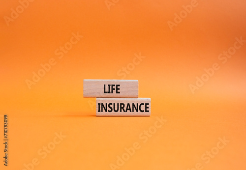 Life insurance symbol. Concept word Life insurance on wooden blocks. Beautiful orange background. Business and Life insurance concept. Copy space