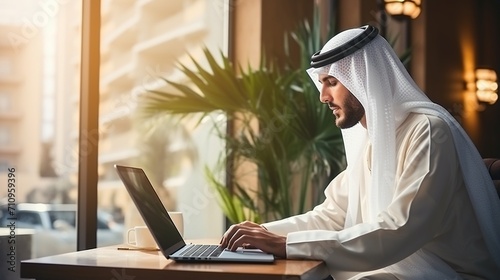 Arab man using laptop in cafe