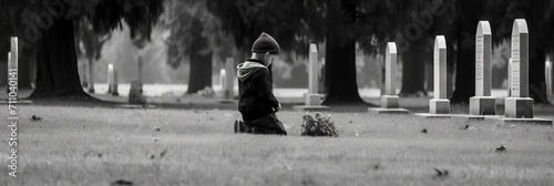 A child at a gravestone in a cemetery with a bouquet of flowers. Concept: grief from the loss of a loved one, burial and depression. 
