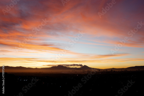 Sunrise in Mexico City with skyline and volcanoes