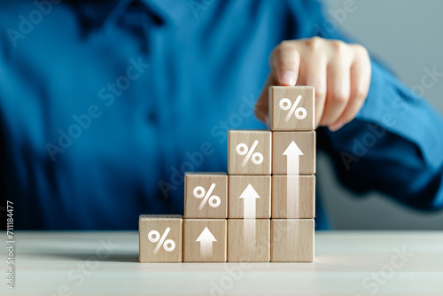 Wooden block with percentage sign and arrow up, Interest rate and dividend concept, interest rate, tax, VAT, real estate, return on stocks and mutual funds, business growth income and profit.