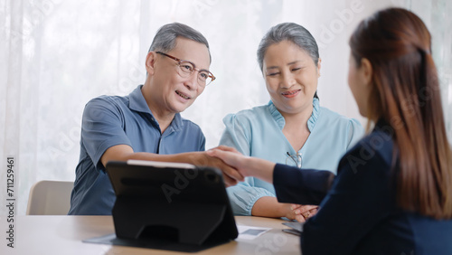 Financial advisor,realtor agent,insurance,lawyer,Manage your retirement fund concept.Financial advisor showing presentation on computer,deal shake hand to happiness Elderly asian couple retirement