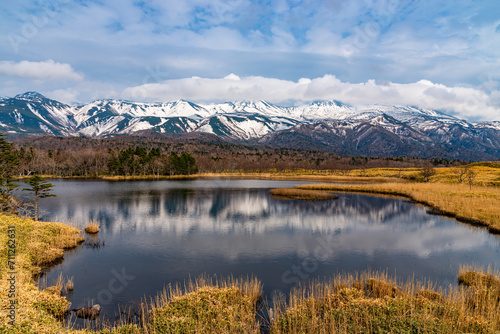 Beautiful lake and rolling mountain range on springtime sunny day. High latitude country natural beauty scenery. The First Lake of Shiretoko Goko Five Lakes, Shiretoko National Park. Hokkaido, Japan
