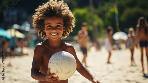 Happy African-American boy playing on the beach with a ball