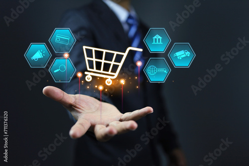 Digital marketing concept with businessman holding a shopping cart to promote online shopping application to offer discount and free shipping delivery