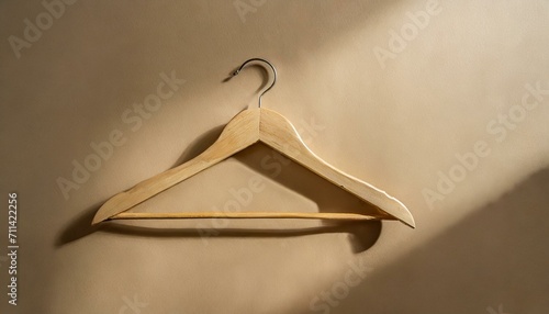 coat hanger.a wooden hanger against a warm beige backdrop. The image should evoke a sense of simplicity and home organization, making it suitable for interior design or lifestyle content.