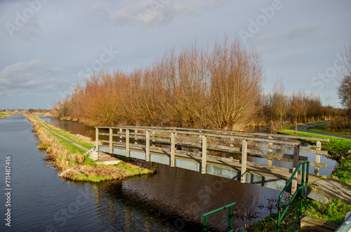 Gouda, The Netherlands, January 6, 2023: narrow pedestrian bridge leading to a hiking trail into the polder