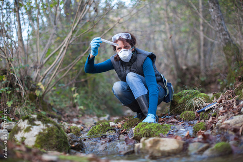 Concentrated Biologist Adult Woman Making On Field Test of Water Stream