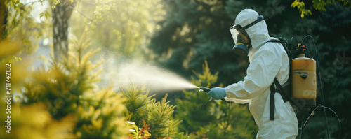 Man in protective suit spring spraying the trees