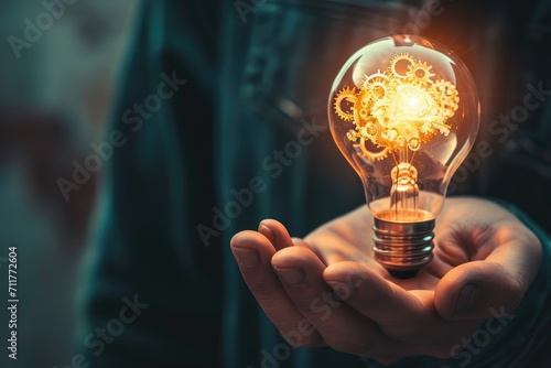 A close-up of a person hand holding a lightbulb, with visible gears and mechanisms inside Hand holding light bulb and business digital marketing innovation technology