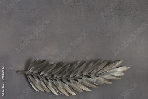 Silver palm leaf on grey backgroun. Ash Wednesday concept. 