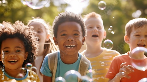 happy multi ethnic group of little friends playing with soap bubbles