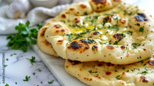 indian naan bread with herbs and garlic seasoning on plate,close up