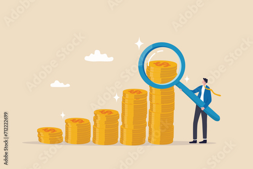 Investment or financial analysis, wealth management or revenue growth, economic or profit improvement, income or portfolio analysis concept, businessman with magnifying glass on growth coin stack.