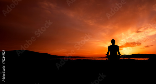 sylwetka kobiety medytującej na plaży przy zachodzie słońca 