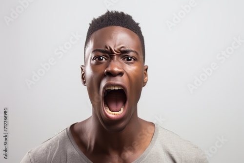 Portrait of african american angry man screaming on white background