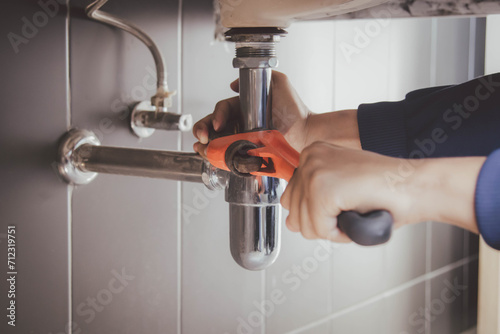 plumber at work in a bathroom, plumbing repair service , fix water plumbing leaks, replace the kitchen sink drain